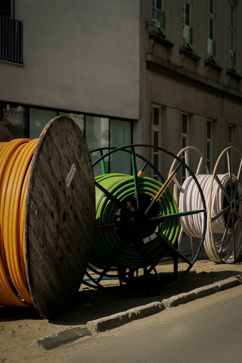 Kabeltrommeln und Rohrsysteme am Rand einer innerstädtischen Baustelle